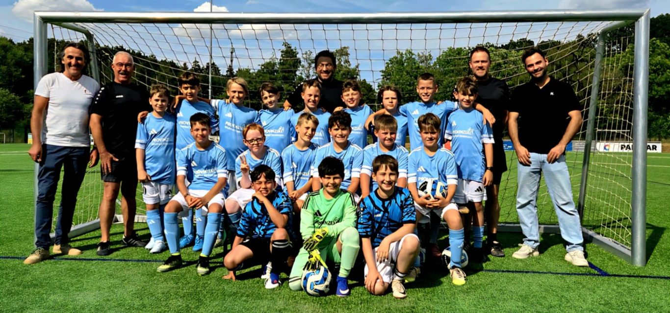D-Junioren JSG Kall/Keldenich/Scheven Gruppenshot einer Jugendfußballmannschaft in gestreiften Trikots auf einem Sportplatz.